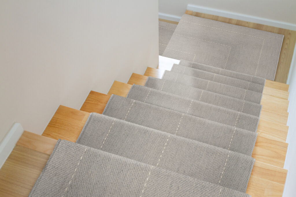 The Design Of Staircase Inside The House Are Paved With Light Brown Wood Laminate.